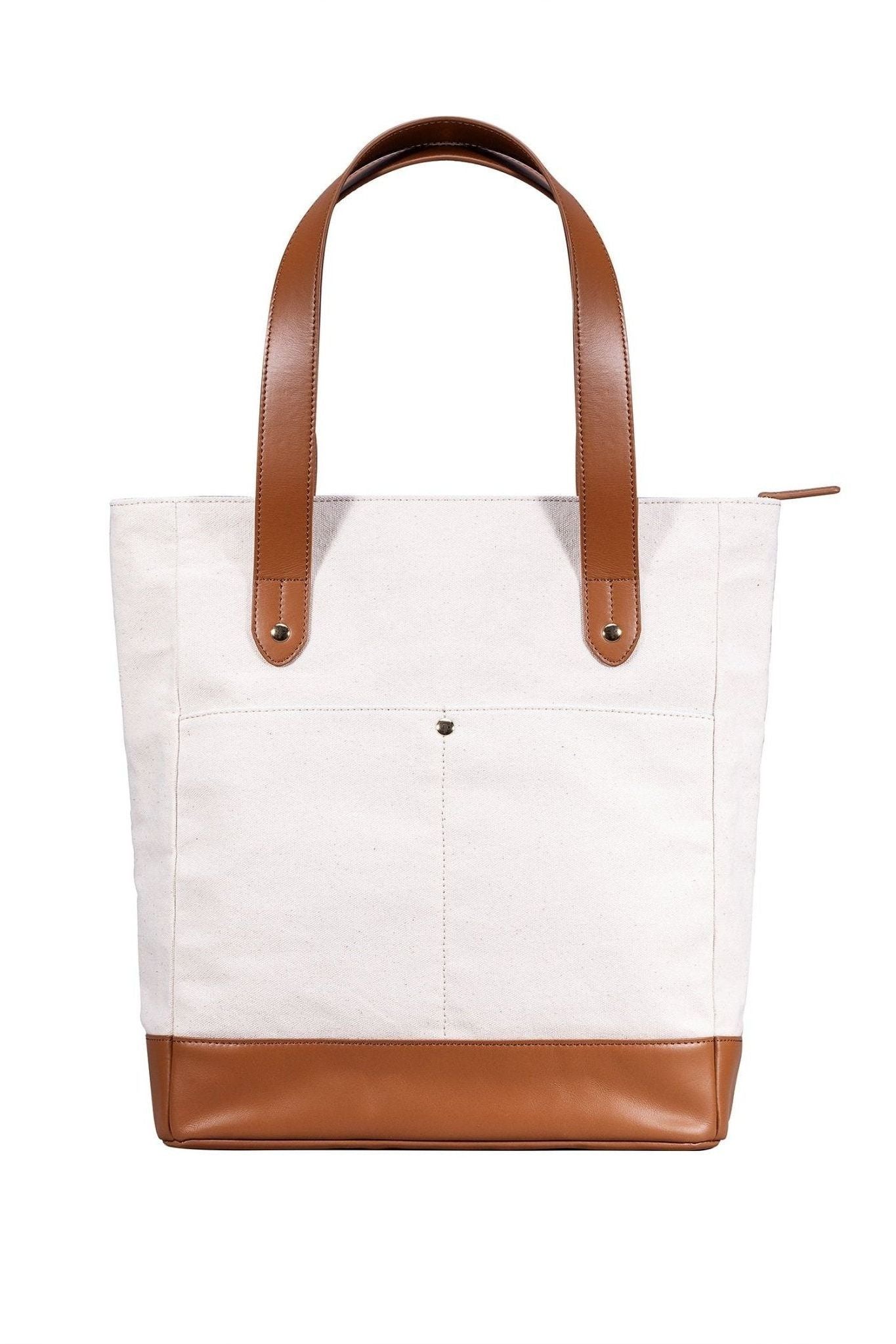 White tote bag with brown leather accents on a white background