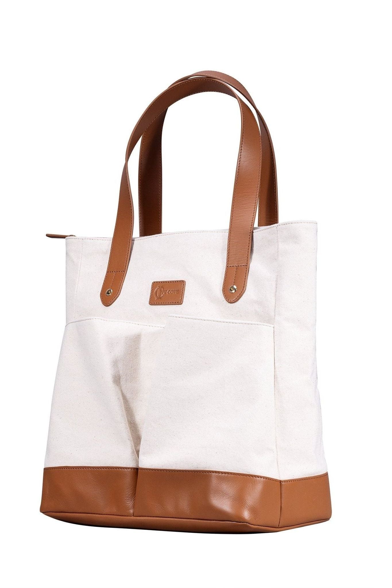 White tote bag with brown leather accents on a white background